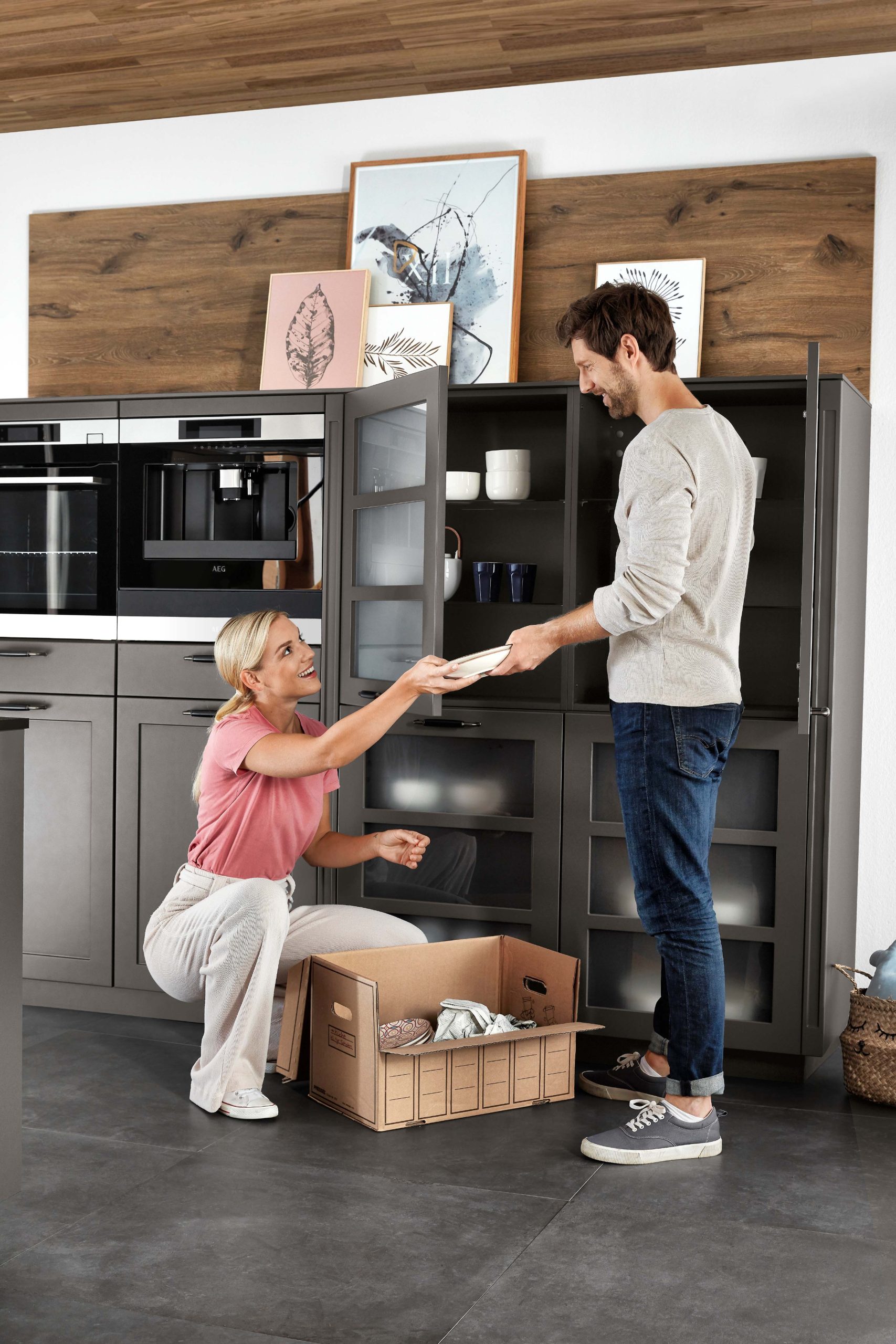 N-line Nordic Keuken. Man en vrouw die samen de keukenkasjes inruimen.